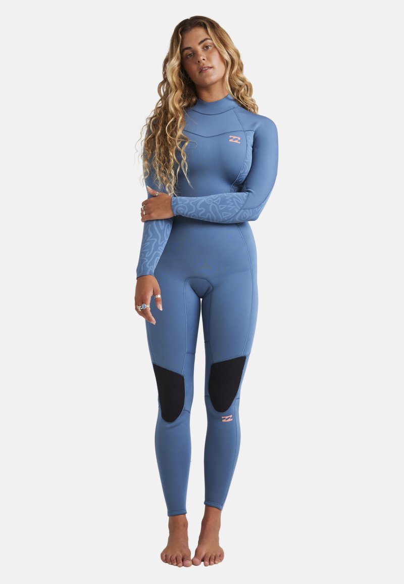 Blue wetsuit with long sleeves and a high neck. Features textured arm patterns and reinforced knee patches. Logo on chest in pink.