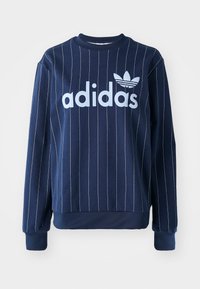 Marinblå sweatshirt med vertikala vita ränder, stort ljusblått "adidas"-logotyp framtill, ribbade ärmslut och rundad halsringning.