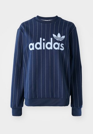 Granatowa bluza z pionowymi białymi paskami, duże jasnoniebieskie logo "adidas" z przodu, ściągacze na rękawach i okrągły dekolt.