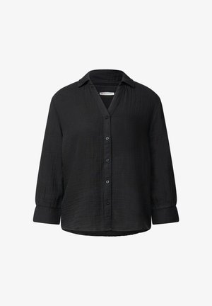 Chemise noire à manches longues avec un col en V et un tissu texturé. Présente une coupe droite et des poignets avec des détails de boutons.