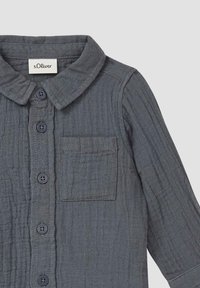 Graues, strukturiertes Hemd mit Kragen, Knopfleiste und Tasche. Merkmale sind dunkle Knöpfe und ein dezentes Streifenmuster im Stoff.