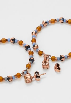 Armband en bijpassende steker oorbellen set met amber, blauwe en zwarte kralen en koperen metalen accenten op een witte achtergrond.