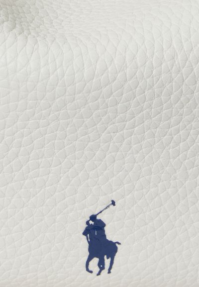 Cuir blanc texturé avec un logo bleu prononcé de joueur de polo, caractérisé par une finition lisse et un motif en relief subtil.