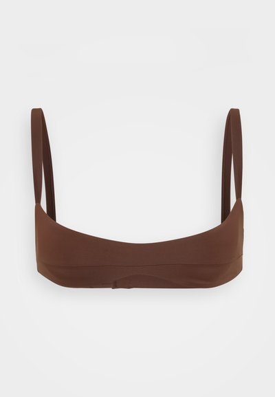 Rudas bikinio viršus, pagamintas iš lygaus audinio, su plonomis petnešėlėmis ir be siūlių dizainu, turintis minimalistinę, kontūruotą formą.