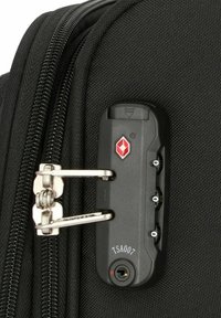 Cerniera di una borsa da viaggio nera con un meccanismo di bloccaggio argentato, dotata di un lucchetto a combinazione TSA e una superficie in tessuto testurizzato.