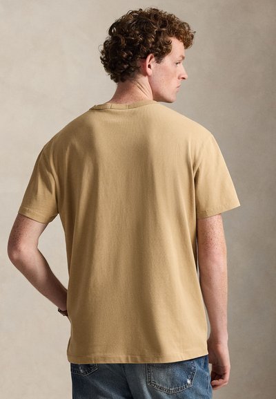 Khaki cotton t-shirt with short sleeves, a round neckline, and a relaxed fit. Smooth texture with no visible patterns or logos.