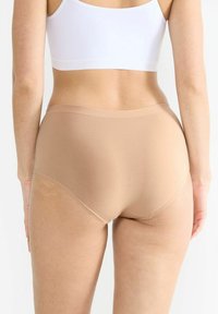 Beige Hochbund-Unterwäsche aus glattem, dehnbarem Stoff. Verfügt über einen einfachen Bund und minimale Nähte für optimalen Komfort.