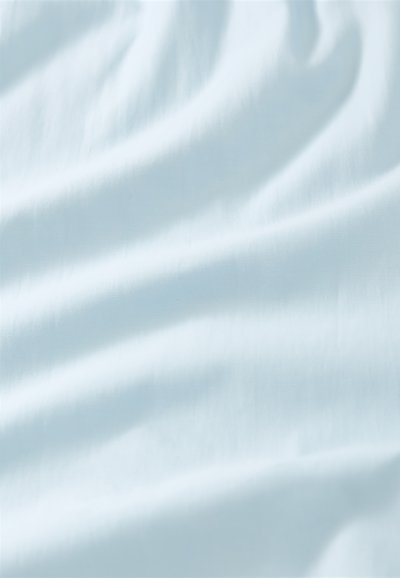 Tissu bleu pâle doux avec de légers plis et ombres créant une texture lisse et fluide.