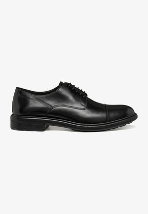 Chaussure Oxford en cuir noir poli avec laçage fermé, bout droit et petit talon empilé, vue de profil latéral.
