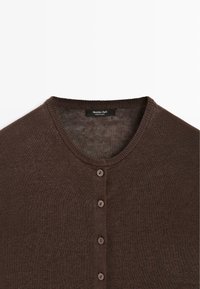 Brązowy sweter kardigan z okrągłym dekoltem, pięć guzików z przodu oraz metka Massimo Dutti wewnątrz kołnierza.