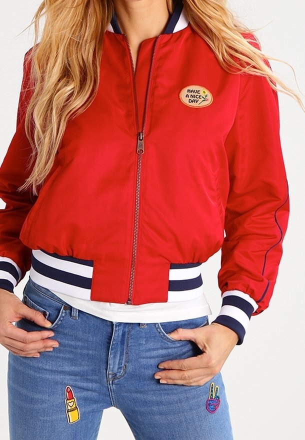 Czerwona bomberka z granatowymi paskami na kołnierzu i rękawach, z naszywką "MIŁEGO DNIA" oraz skróconym fasonem.