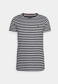 Pruhované tričko s horizontálními černobílými pruhy, kulatým výstřihem, krátkými rukávy a malým logem na hrudi.