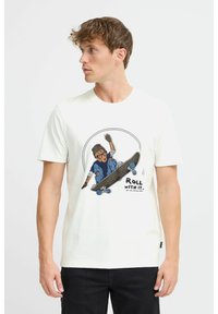 Hvid bomulds t-shirt med et farverigt grafik af en skateboarder og teksten "ROLL WITH IT" nedenfor. Afslappet pasform og rund halsudskæring.