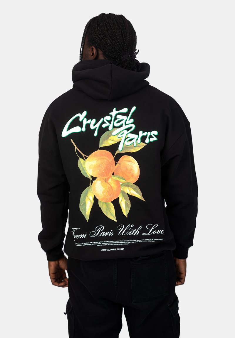 Felpa nera con un grafiche colorato di arance e foglie verdi. Il testo dice "Crystal Paris" e "From Paris With Love."