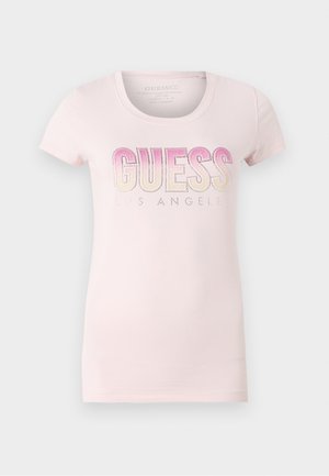 Tricou din bumbac de culoare roz deschis, cu guler rotund, mâneci scurte și text decorativ cu gradient "GUESS LOS ANGELES" accentuat cu strasuri.