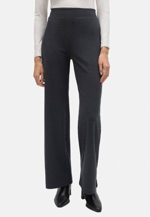Pantalones de pierna ancha en gris oscuro, confeccionados en un material suave, con una cintura alta, textura lisa y corte recto, combinados con botas de tacón negras.