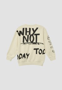 Crèmekleurige sweatshirt met opvallende zwarte tekst en abstracte ontwerpen. De manchetten en zoom zijn elastisch, met een ontspannen pasvorm en zachte textuur.