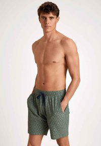 Groene zwemboxers met een elastische tailleband en trekkoord. Gemaakt van gestructureerde stof, met zijzakken en een ontspannen pasvorm.