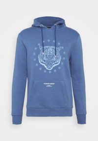 Blaue Kapuzenjacke aus weichem Stoff mit einem Tiger-Motiv, umgeben von Sternen, vorn mit einer Tasche und verstellbarem Kordelzug an der Kapuze.