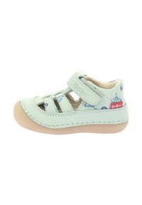 Sandal de cuero verde claro con múltiples correas, punta redondeada y suela de goma de color beige claro. Presenta divertidos patrones temáticos del océano en azul.