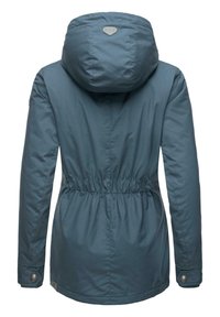 Teal udendørsjakke med hætte, elastisk snøring i taljen og trykknapmanchetter. Har en glat tekstur og et logo-patch på ryggen.