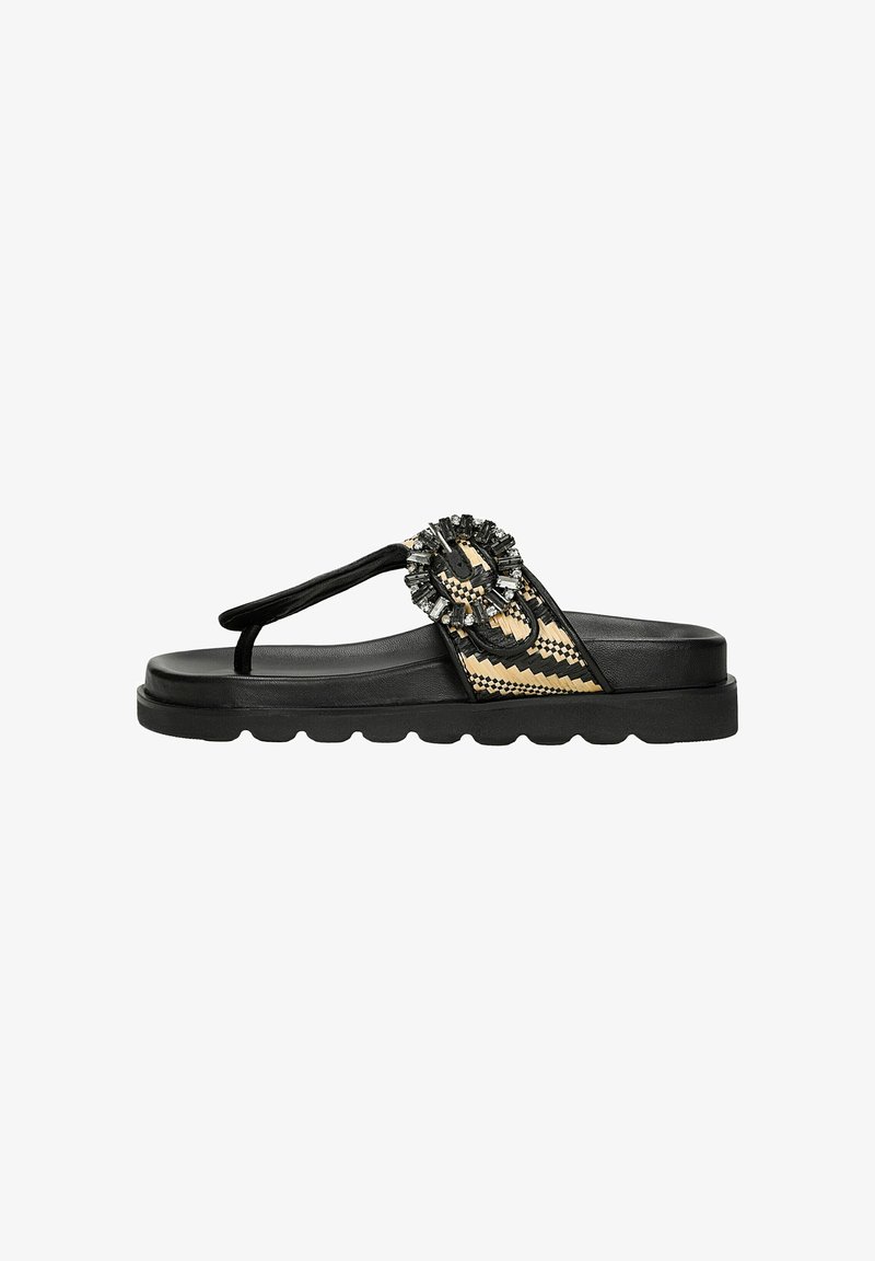 Black flat sandals with a textured sole, featuring a decorative fabric strap with a beaded accent and a woven design in beige tones.