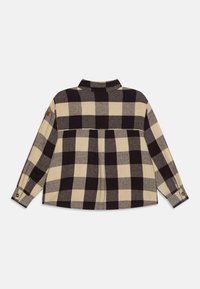 Camicia di flanella a scacchi in bianco e nero. Presenta un colletto, polsini con bottone e un design a yoke con parte posteriore plissettata. Tessuto morbido.