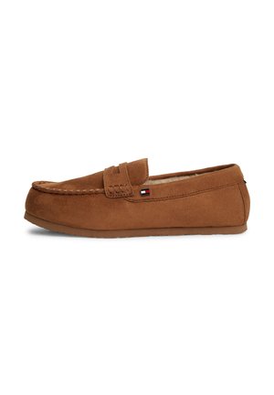 Mocassin marron en daim à enfiler avec bout moc cousu et doublure douce, avec un petit logo rectangulaire sur le côté.