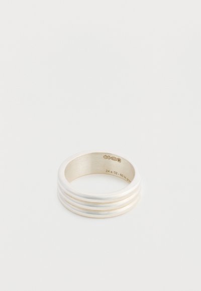 Bague en argent avec une finition lisse et polie, ornée de trois bandes en relief. Gravure intérieure visible. Forme ronde avec un intérieur mat.