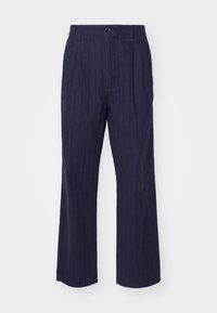 Laivastonsiniset housut pystysuuntaisilla kapeilla raidoilla, valmistettu pehmeästä kankaasta; suora lahjemalli, nappisuljenta ja etumaiset laskokset.