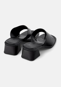 Svarte lærplattform sandaler med åpen tå og to brede stropper. Firkantet hæl, glatt tekstur, minimalistisk design.