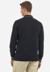 Polo a maniche lunghe di colore blu navy, realizzato in morbido cotone. Presenta un colletto e polsini a costine. Design semplice, senza motivi visibili.