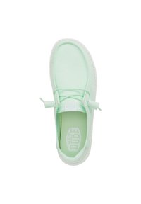 Scarpa slip-on in tela verde chiaro con suola in gomma bianca testurizzata, dettagli in pizzo regolabili e soletta marchiata.