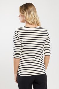 Bluzka w paski z białymi i granatowymi poziomymi paskami, okrągłym dekoltem i rękawami o długości trzech czwarci. Miękki, dzianinowy materiał o dopasowanym kroju.