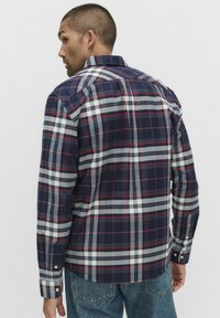Koszula w kratę w kolorze granatowym z czerwonymi i białymi liniami, z kołnierzykiem zapinanym na guziki, długimi rękawami i guzikami przy mankietach; wykonana z teksturowanej tkaniny.