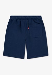 Shorts en coton bleu marine avec une ceinture élastique, dotés d'une poche plaquée à l'arrière et d'une petite étiquette logo près de la taille. Texture lisse.