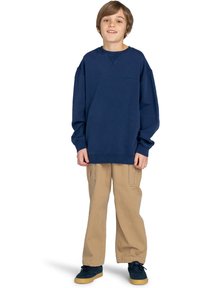 Felpa blu navy con polsini a coste, vestibilità rilassata, abbinata a pantaloni cargo beige, con numerose tasche e design a gamba dritta.