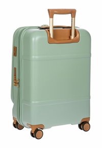 Harde koffer in mintgroen met beige accenten, uitschuifbare handgreep, dubbele ritsen en vier zwarte wielen voor mobiliteit. Glad oppervlak.