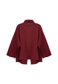 Oversizowa bordowa bluzka z długim rękawem, z wysokim dekoltem, luźnym fasonem oraz lekko zaokrąglonym dołem z małym rozcięciem na środku tyłu.