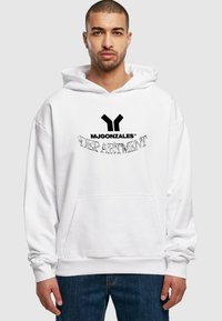 Valge kapuutsiga dressipluus musta logo "MJGONZALES" ja "DEPARTMENT." Omab eesmist taskut ja on laia lõikega, valmistatud pehmest kangast.