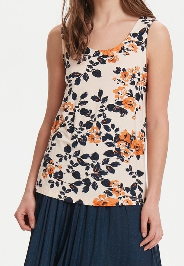 Débardeur floral couleur crème avec imprimé floral orange et bleu marine ; doté d'un col rond et d'un tissu doux et extensible. Associé à une jupe bleu marine.