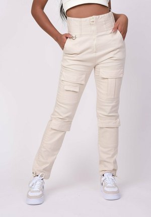 Pantalons cargo beiges à taille haute avec plusieurs poches, fermeture éclair et liens aux chevilles. Fabriqués en tissu durable avec une texture lisse.