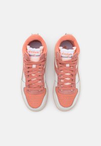 Sneakers rosa e bianchi con una tomaia texture, punta rotonda, design perforato sulla parte anteriore e suola in gomma. Logo sulla linguetta imbottita.