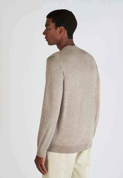 Suéter de punto marrón claro con mangas largas, escote redondo y puños acanalados. Textura suave con un suave patrón de grano.