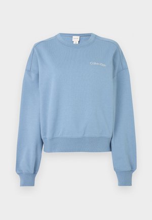 Modra bombažna majica s dolgimi rokavi in krožnim izrezom. Na prsih ima belo logo Calvin Klein. Ribasti manšeti in rob.