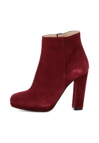 Bottine en suède bordeaux avec un talon bloc haut, un bout arrondi et une fermeture éclair latérale. Texture lisse avec une finition mate.