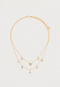 Χρυσό έθνικ κολιέ με τρία στρώματα αλυσίδων με διάφορα μενταγιόν, συμπεριλαμβανομένου ενός κυκλικού μενταγιόν και διακοσμητικών ανθικών σχημάτων.