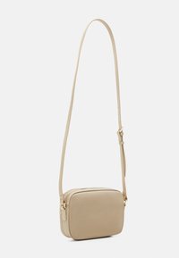 Beige læder crossbody taske med rektangulær form, justerbar rem, lynlås-lukning og subtil tekstur. Hardware i guld-tone detaljer.
