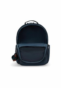 Zaino blu navy realizzato in tessuto morbido, con una forma arrotondata, chiusura con zip e una tasca frontale con un piccolo portachiavi a forma di scimmia di peluche.