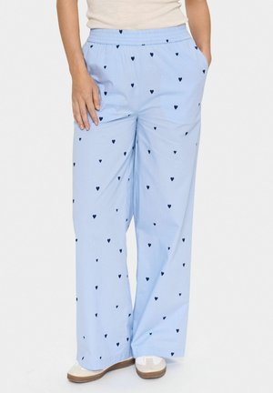 Light blue wide-leg pants made of soft fabric, featuring a pattern of small navy hearts. Elastic waistband and side pockets for comfort.